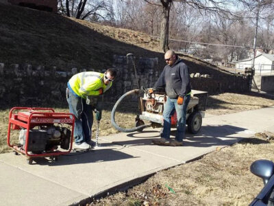 Workers Fixing Sidewalk by Mudjack Concrete LLC